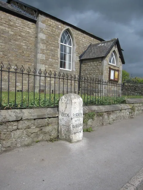 A direction stone and Fraser Hall, Cowan Bridge